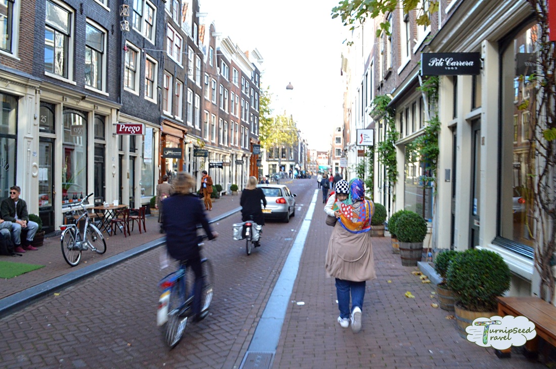 Cycling in Amsterdam: People on bikes on a side street