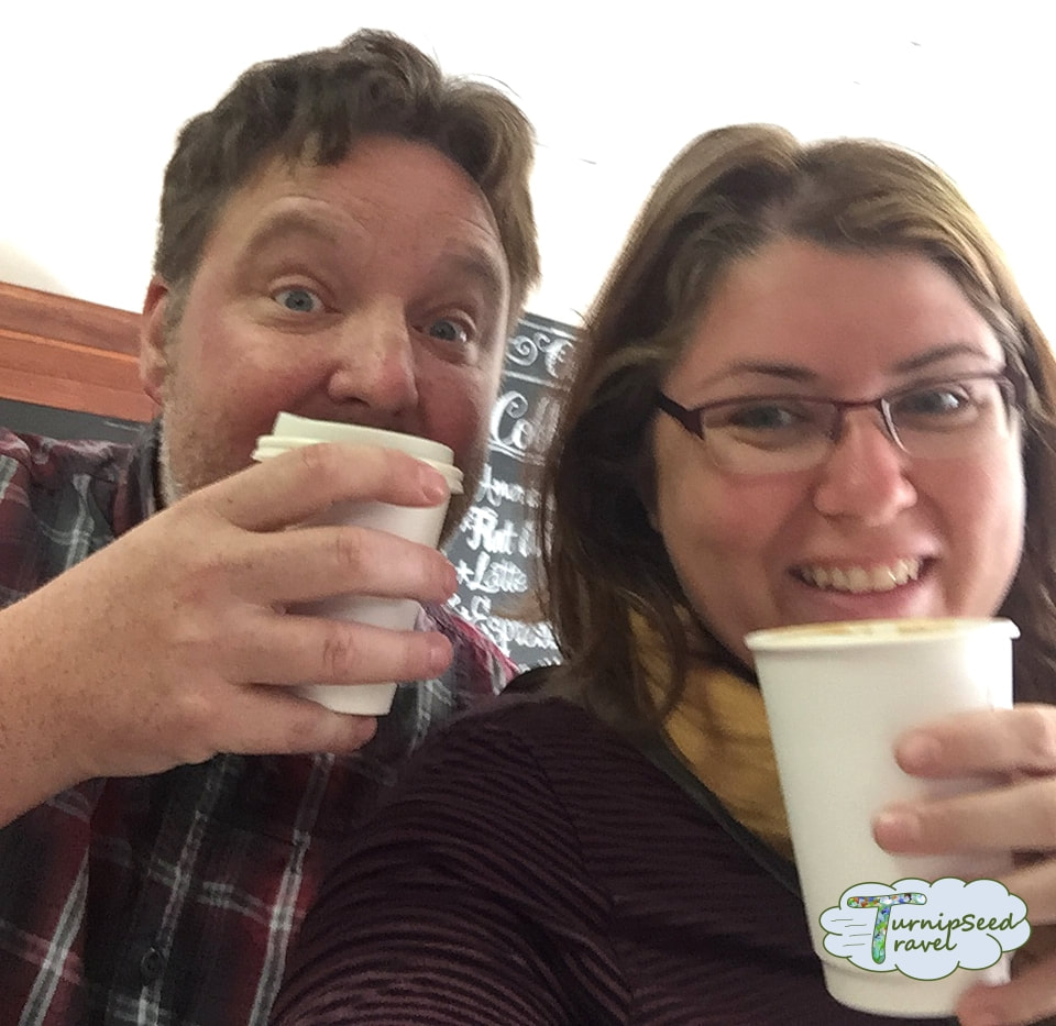 Ryan and Vanessa take a selfie with coffee cups.