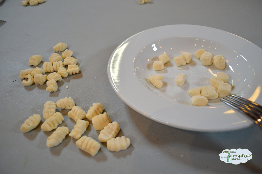 Making gnocchi with a fork and a white plate