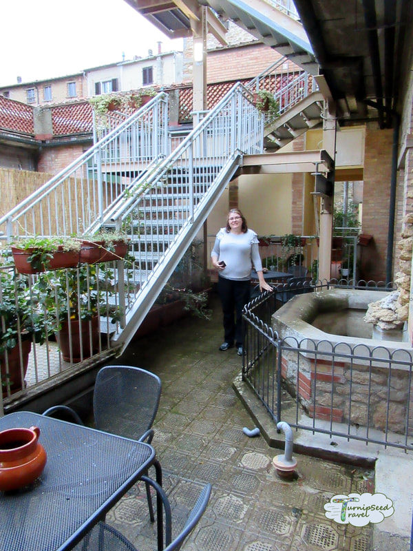 Vanessa stands in a courtyard balcony at an Italian hotel Picture