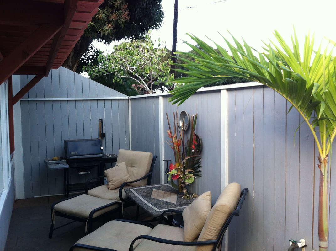 Small patio with two lounge chairs and a BBQ Picture