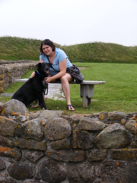 Vanessa and Chester the dog sit at a historic fort