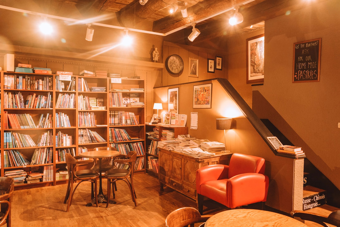 Interior of Books and Bar: Shelves of books and chairs to sit and read with art on the wallsPicture