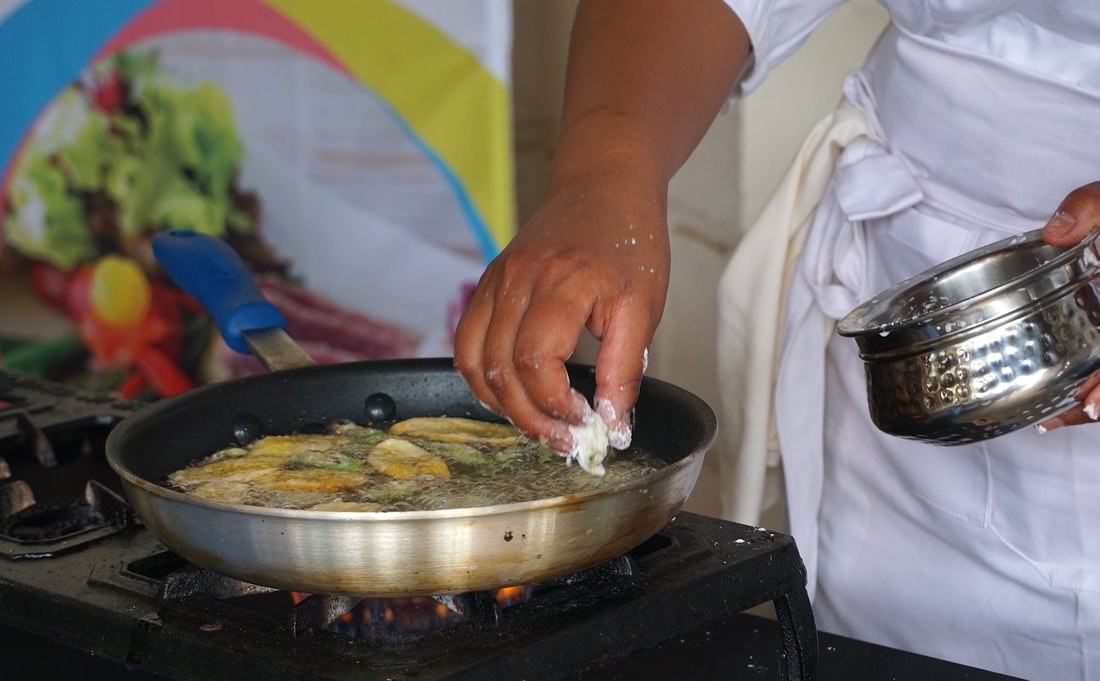 Close up of the chef putting slices of plantain into a frying pan of oil Picture