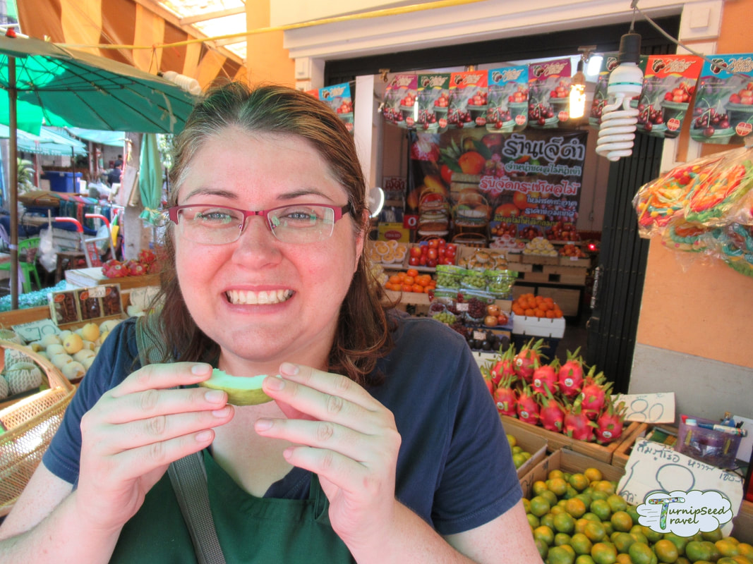 Trying white guava at a Bangkok market fruit stall 
