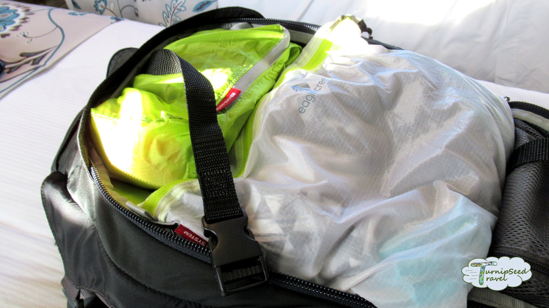 Backpack with white and green packing cubes to illustrate minimalist packing lists and traveling with paracord Picture