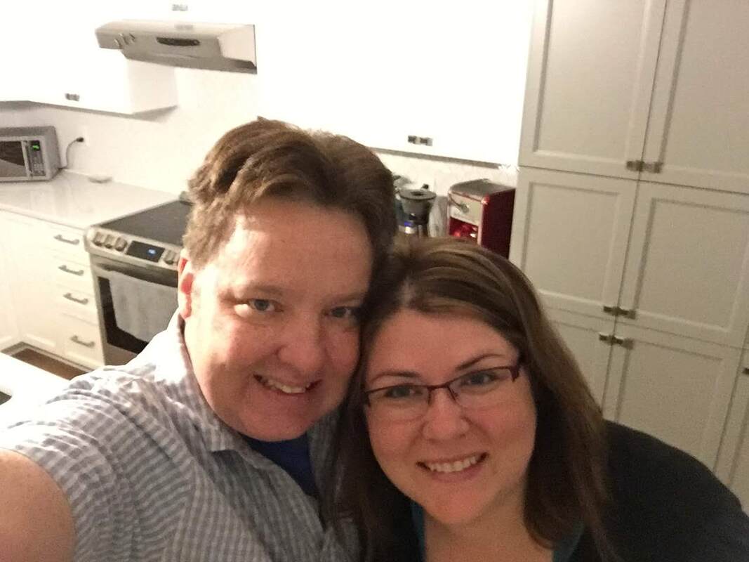 Vanessa and Ryan take a selfie in their white home kitchen. 