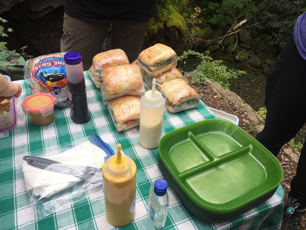 Camping table set up with sandwiches and condiments