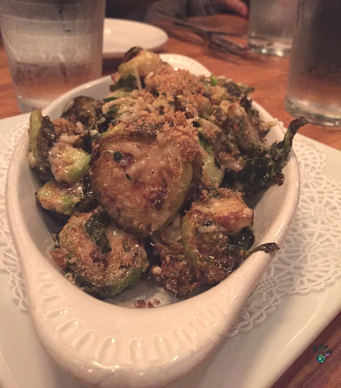 An oblong white dish of roasted Brussels sprouts with crusted cheese and bread crumbs on top at the Tupelo Grille in Whitefish Montana Picture