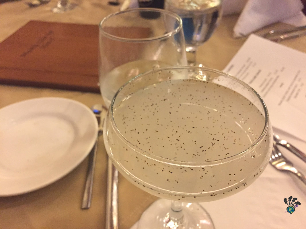 Old fashioned champagne flute filled with a cocktail speckled with black pepper. Whistling Andy Distillery and the Many Glacier Hotel's Ptarmigan Dining RoomPicture