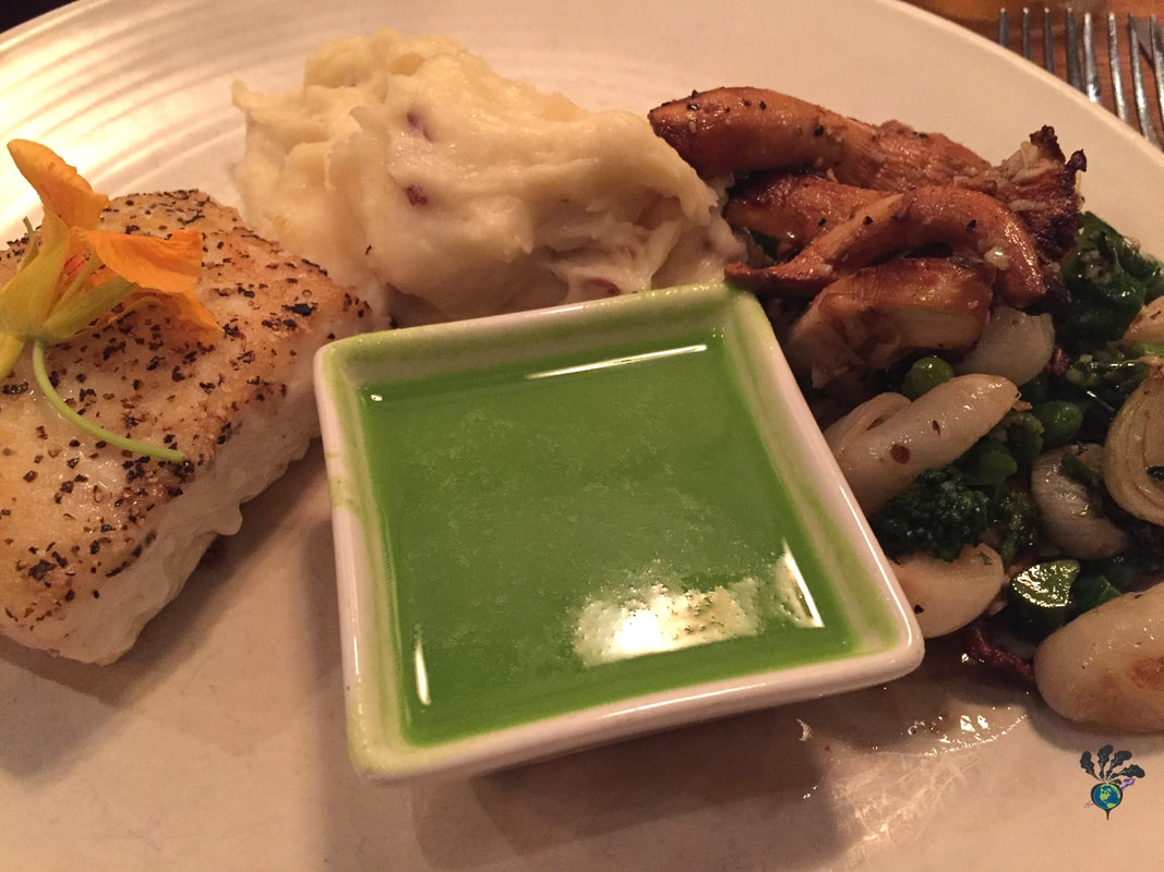 A plate showing baked halibut, mashed potatoes, mushrooms, green vegetables, and a bowl of bright green asparagus puree at Tupelo Grille in Whitefish Montana Picture