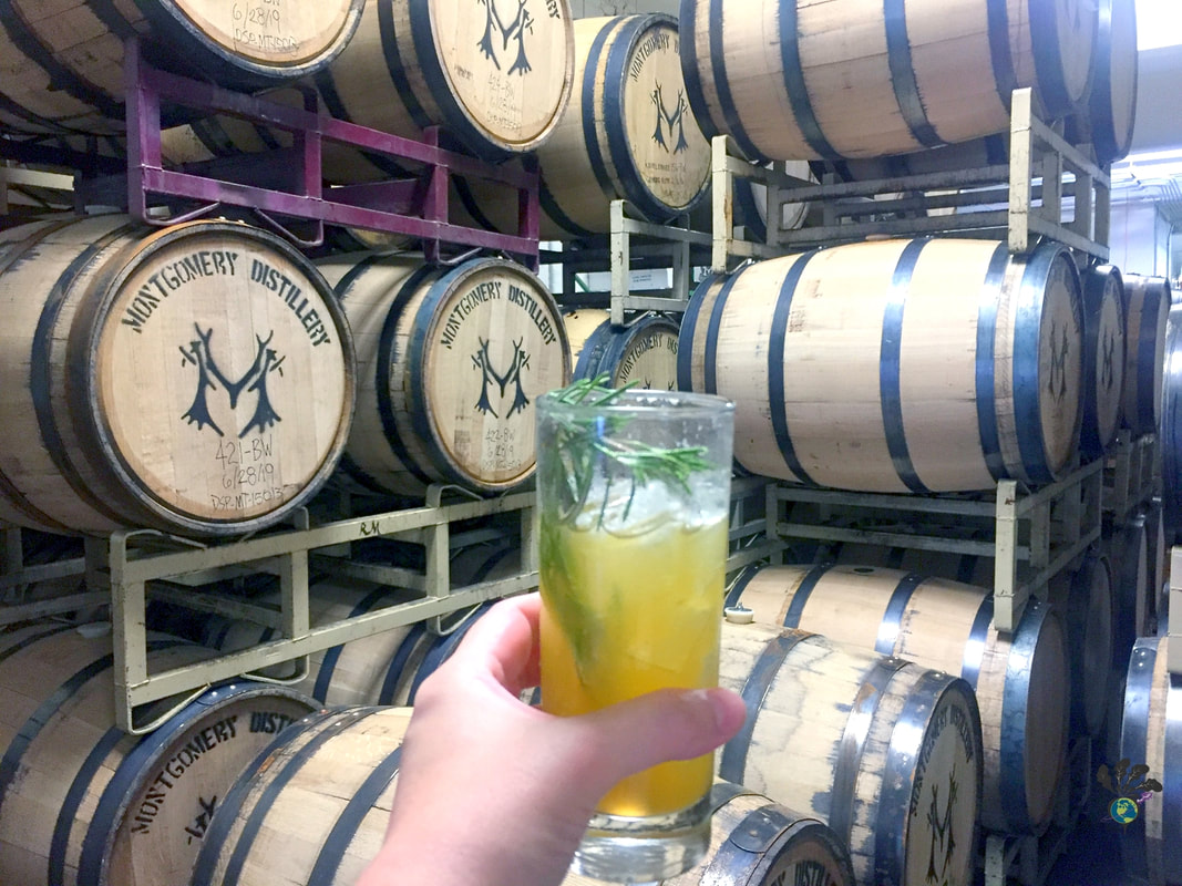 Made in Montana: Visiting a Montana Distillery to see stacks of barrels, with highball cocktail glass in my hand.Picture