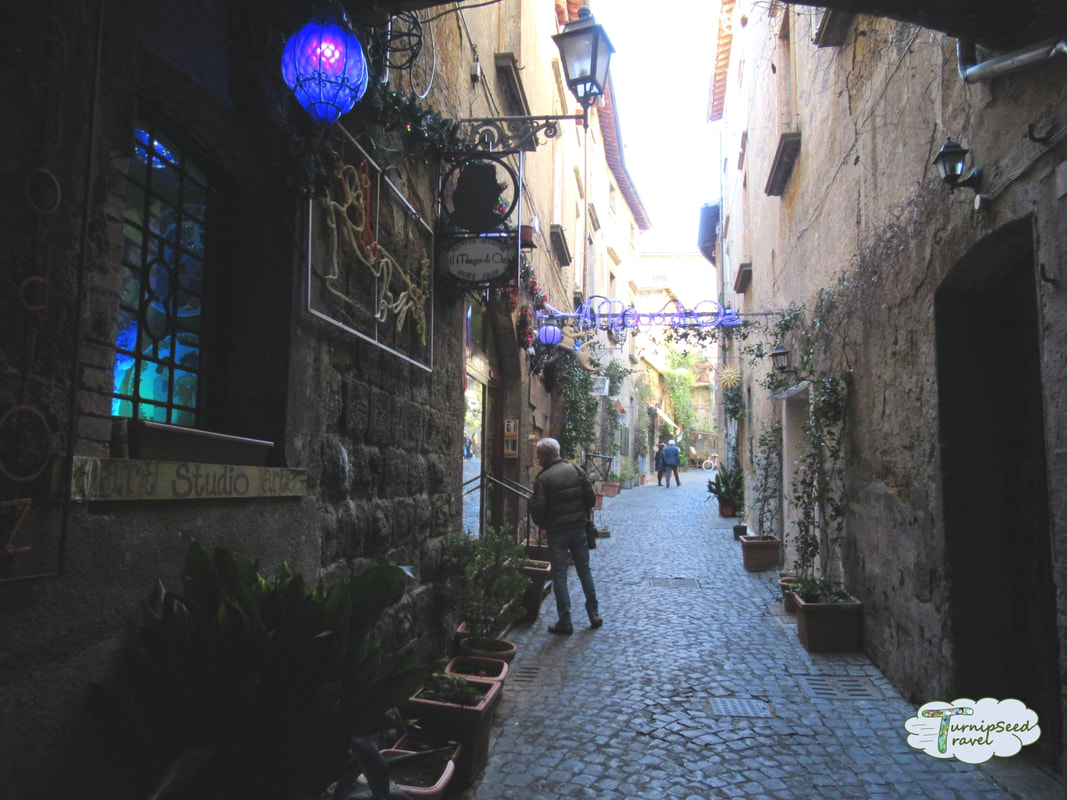 Shops down a cobblestone alley in Orvieto by TurnipseedTravel