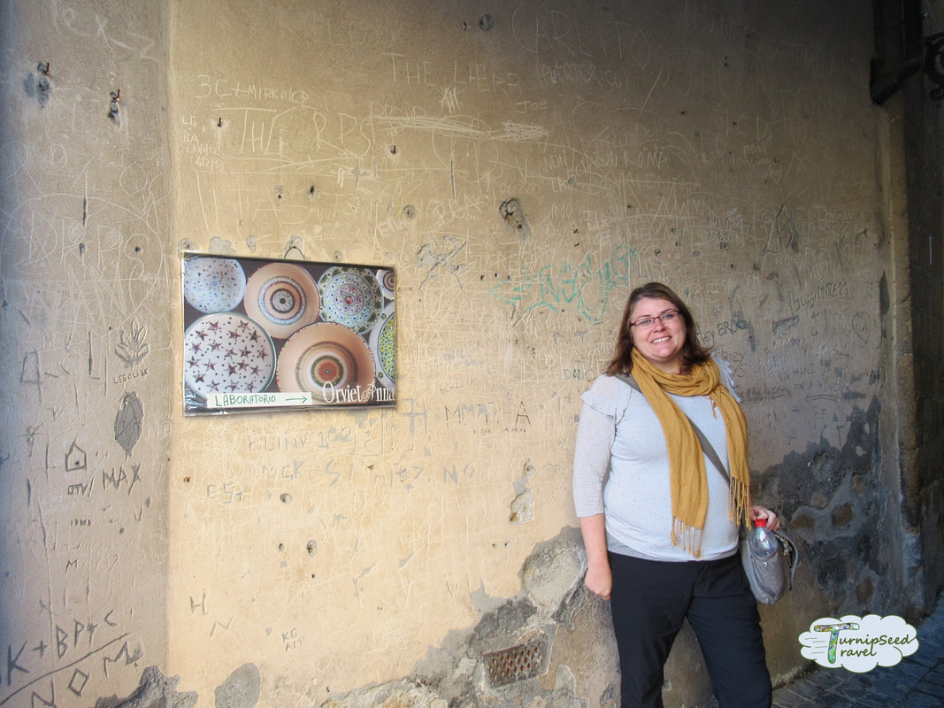 Posing next to a pottery shop sign in Orvieto by TurnipseedTravel