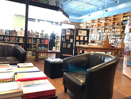 Black leather chair and coffee table surrounded by bookshelves Picture
