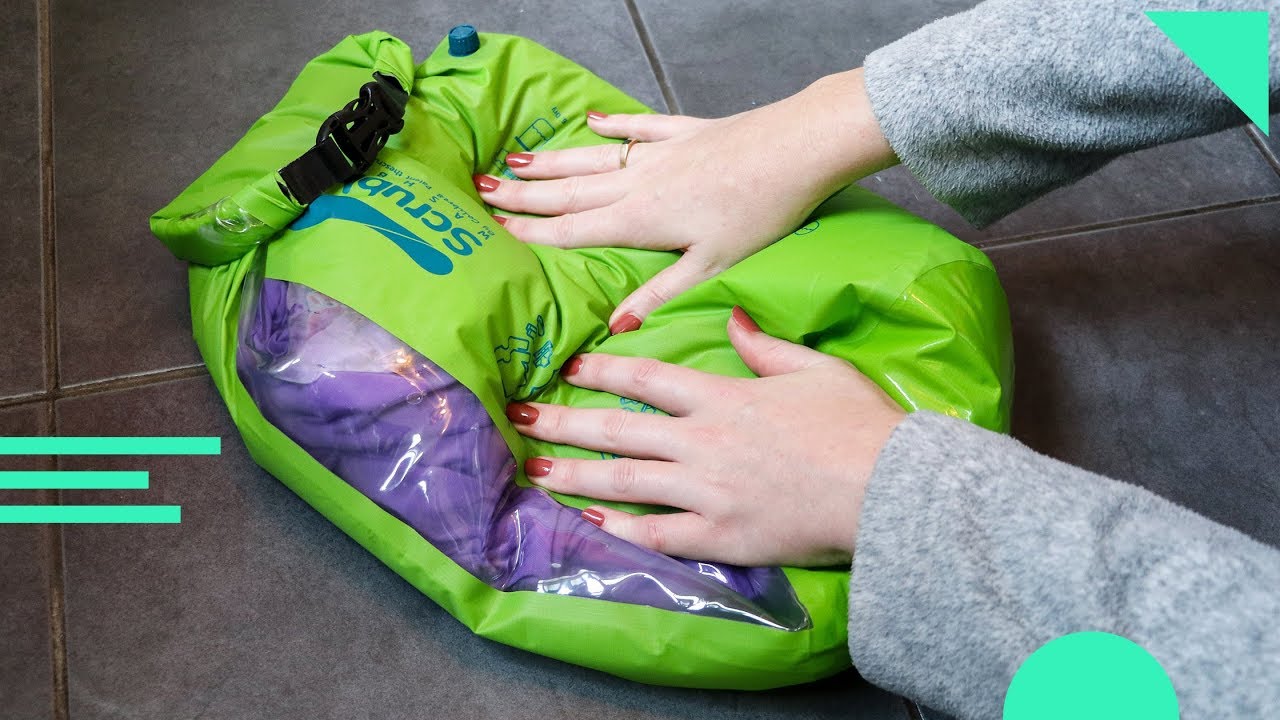 Scrubba Wash Bag review with a bright green wash bag being used by someone wearing a grey sweater