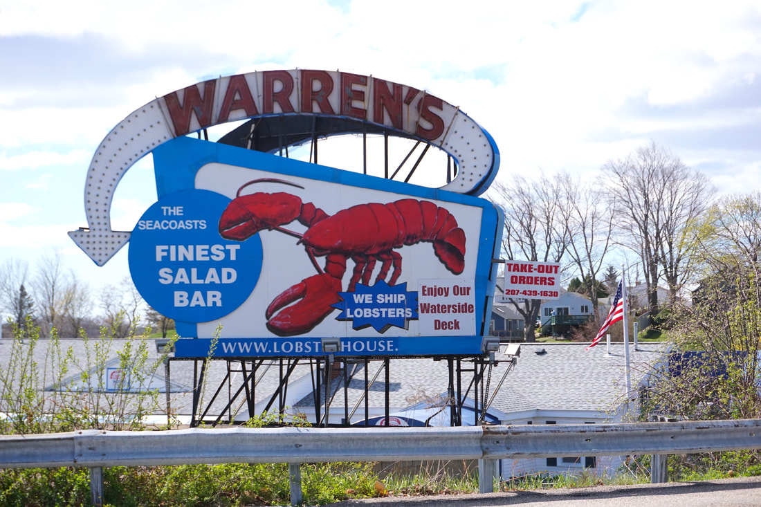  large blue, white, and red sign for Warren's, showing a giant lobster and an arrow pointing to where the restaurant is located.