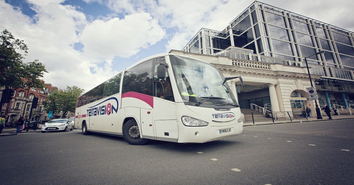 A white Terravision bus with pink and blue details Picture