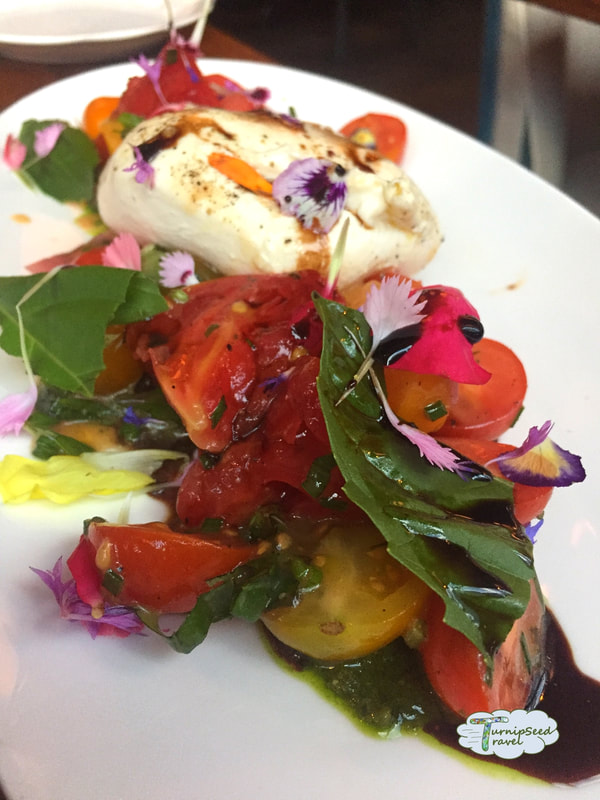 Burrata and heirloom tomato salad with edible flowers and balsamic dressing at Casa Luca in Washington DC Picture