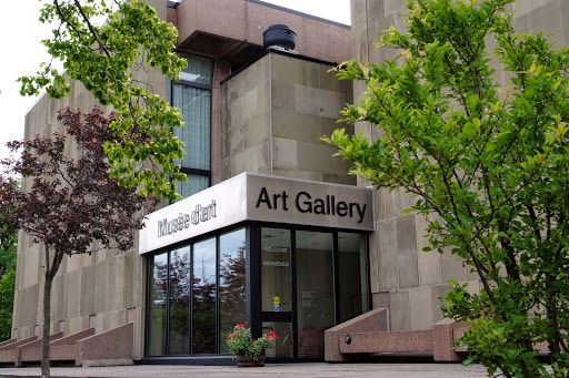 Entrance to the art gallery in a Brutalist style building with two trees outside