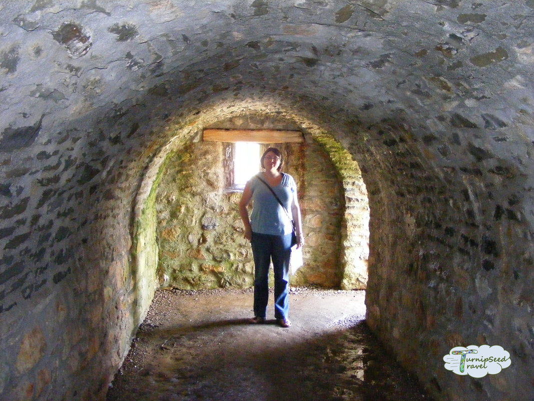 Vanessa stands in a stone tunnel