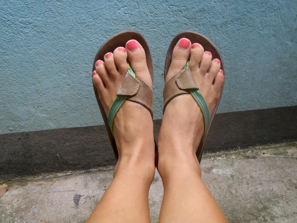 Feet wearing brown flip flops Picture