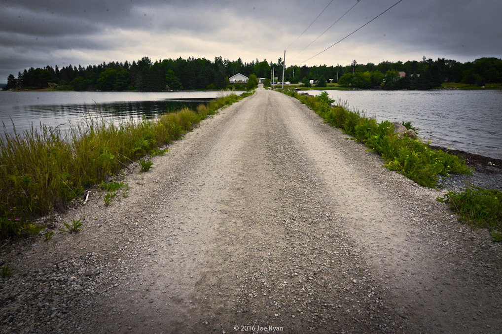 A long gravel road with water on either side connects an island to the mainland.Picture