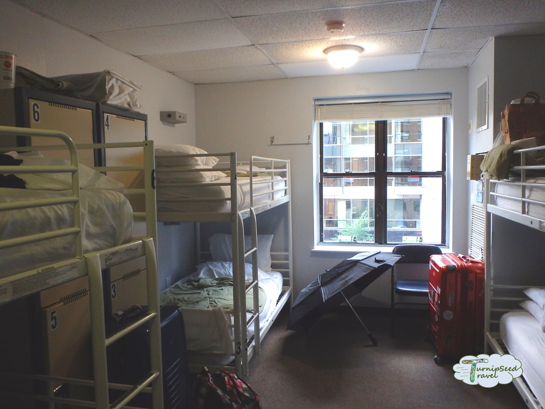 A six bed dorm room with personal belongings strewn about