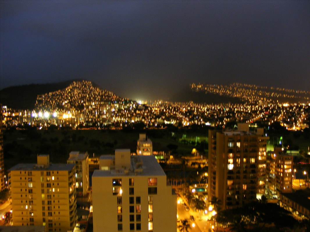 Night time image of glowing lights and buildings in Honolulu