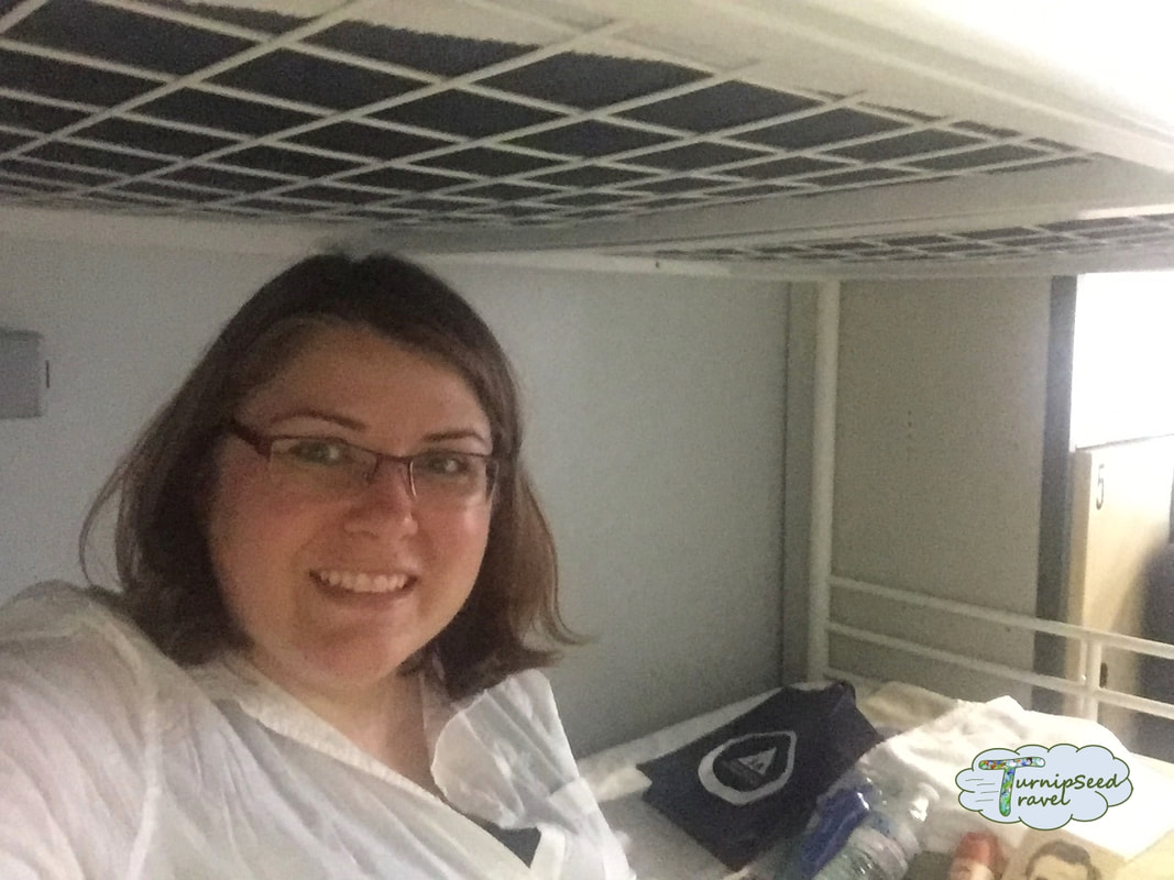 Vanessa takes a selfie from the lower bunk of a hostel bunk bed