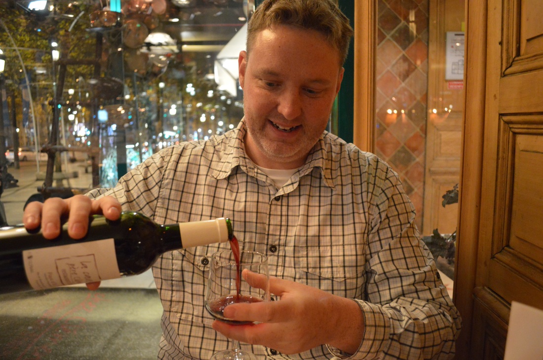 Ryan pouring a glass of wine in a Paris restaurant Picture