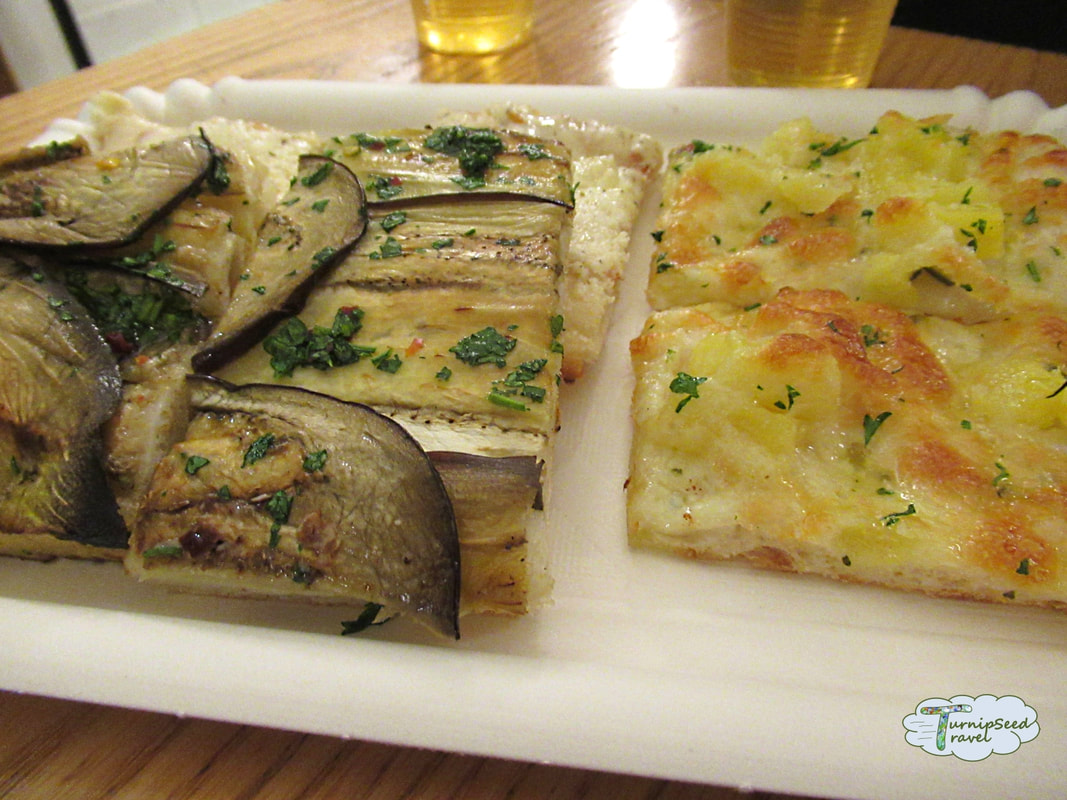 Square slices of eggplant pizza and potato pizza on a white plate.Picture
