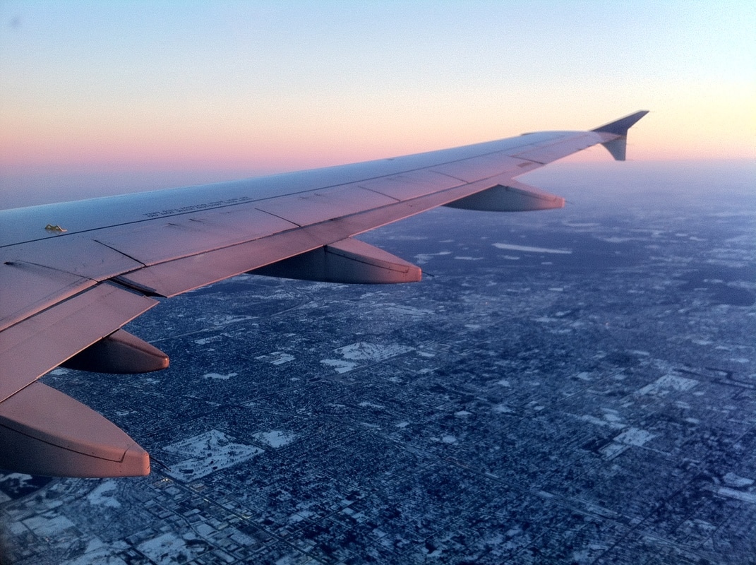 What to do when your flight is delayed. Picture shows wing of a plane at sunset.