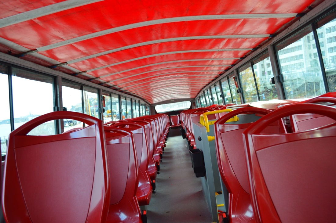 An empty tour bus filled with red seats