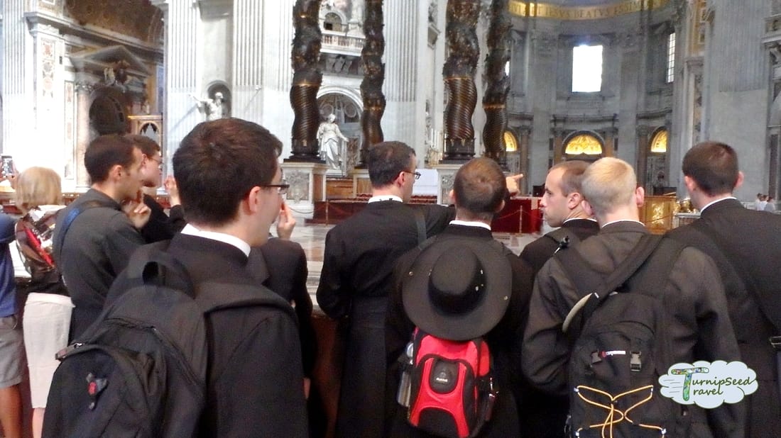Priests in black coats look around St Peter's Picture