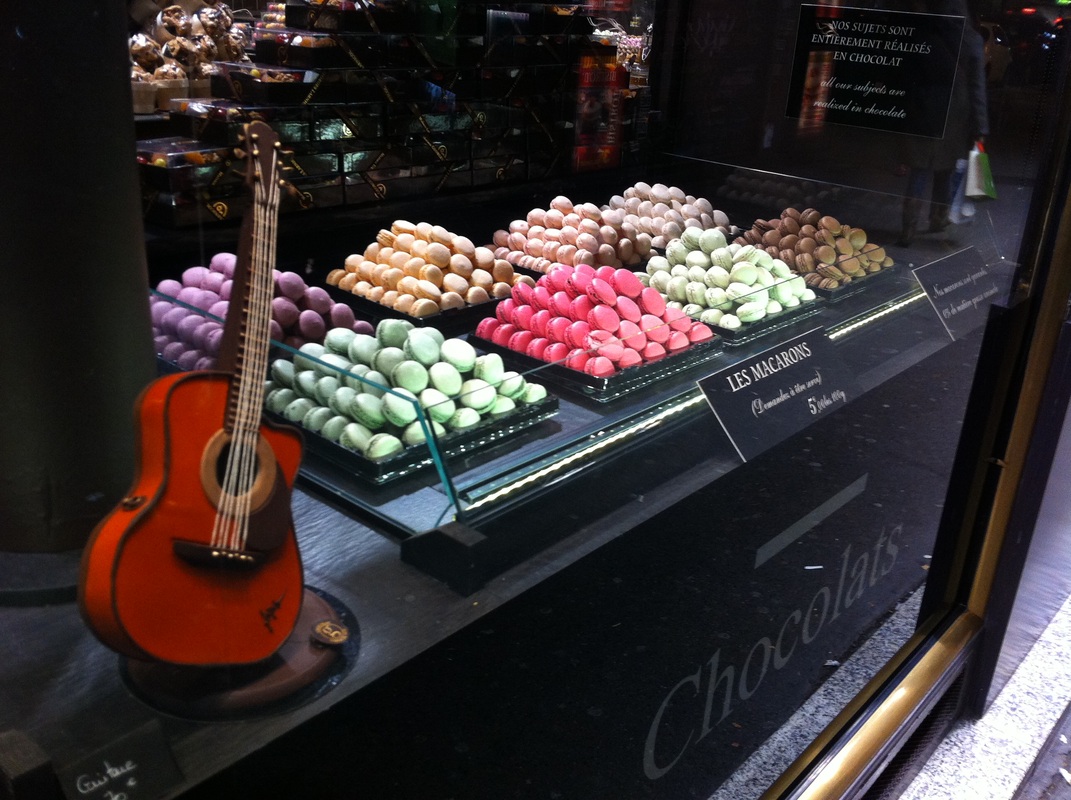 Macarons and a guitar in a window in Paris.