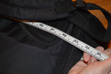 Measuring a backpack with a tape measure Picture