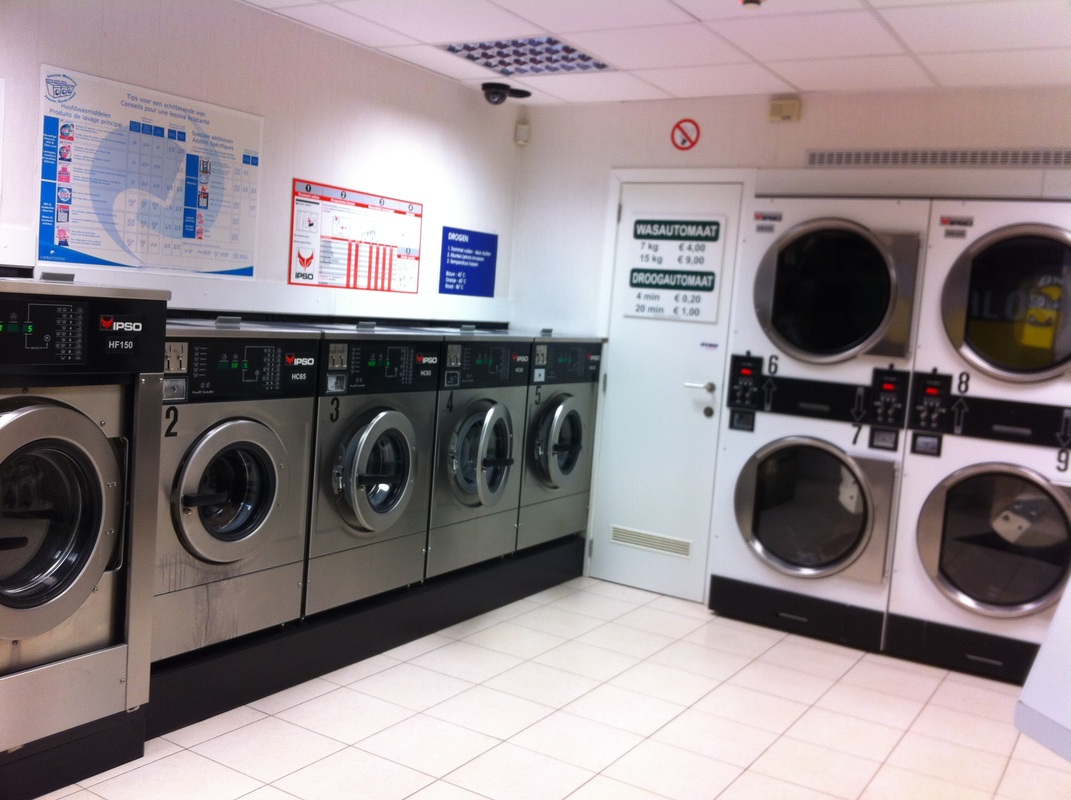 Doing laundry when you travel: Hotel laundry room with multiple washers and dryers Picture