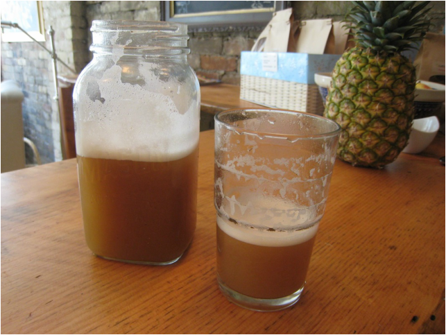 A mason jar and a drinking glass both half filled with tamarind juice Picture