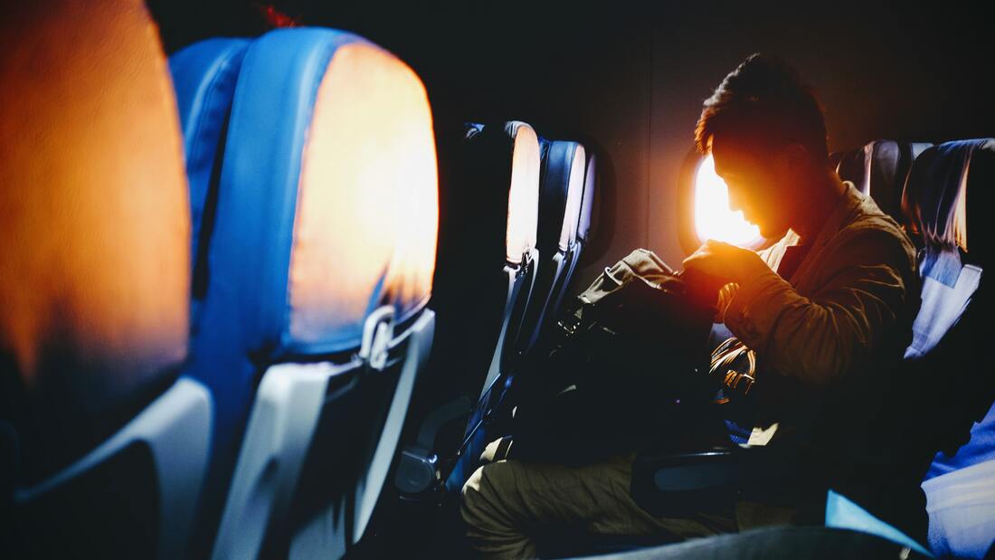 Canadian Transportation Agency Flight Delay Compensation Rules. Single passenger sits on an empty airplane with the sun streaming in