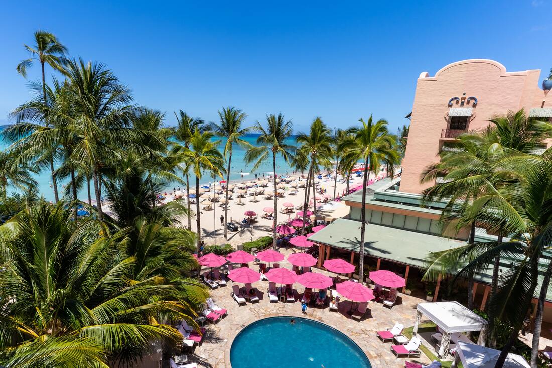 Pink hotel, beach umbrellas, and palm trees