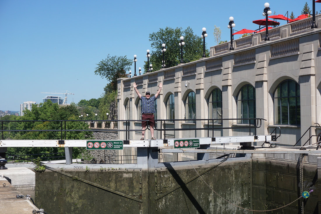 Ryan standing on a pathway connecting the two sides of the Rideau Canal locks next to the side of the Chateau Laurier