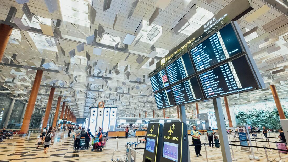 Canadian Transportation Agency Flight Delay Compensation Rules: Bright airport interior with flight information board