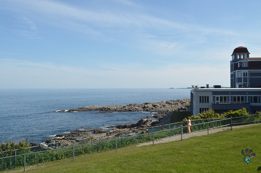 The grounds of the Cliff House, with a walkway along the ocean and a view of the hotel in the background. Picture