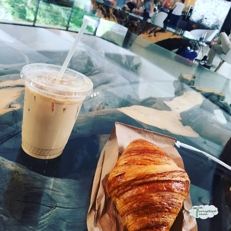 Croissant and iced latte on a glass table with wooden base in the Hirshhorn Museum Picture