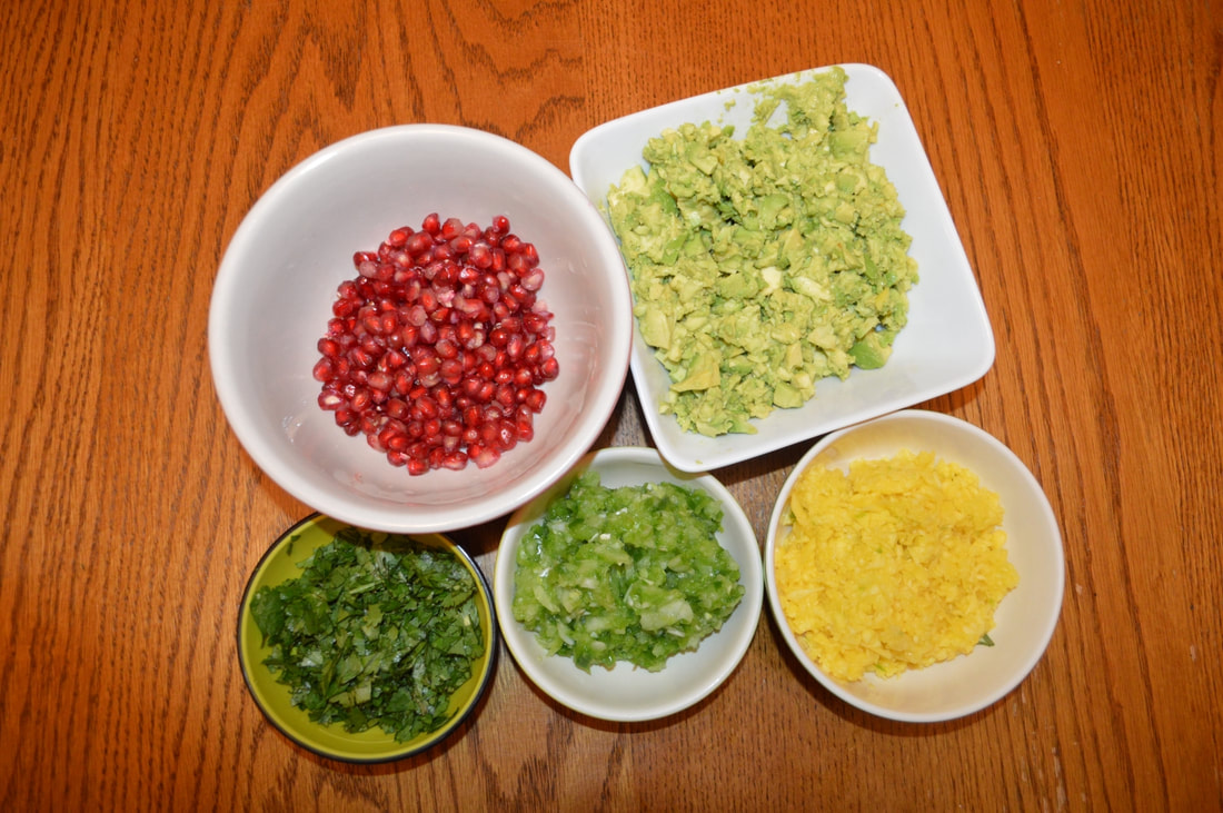Bowls containing the different incredients for avocado mango salad on a wooden tablePicture