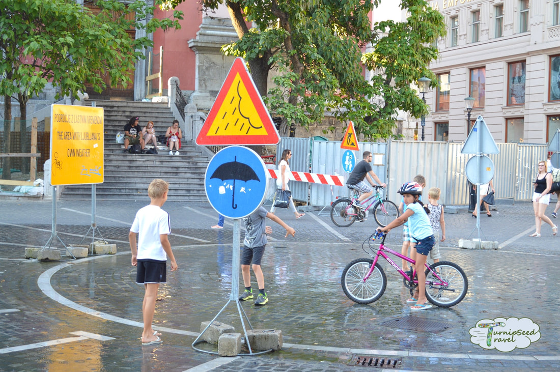 Children play with a street fountain in Ljubljana 