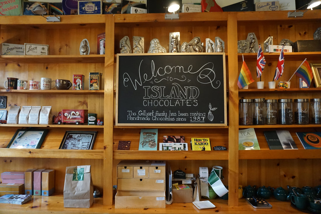 Welcome chalkboard sign and wooden shelves with knick knacks in the coffee shop.Picture