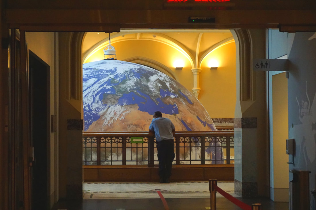 Man looks at a display of the earth at the museumPicture
