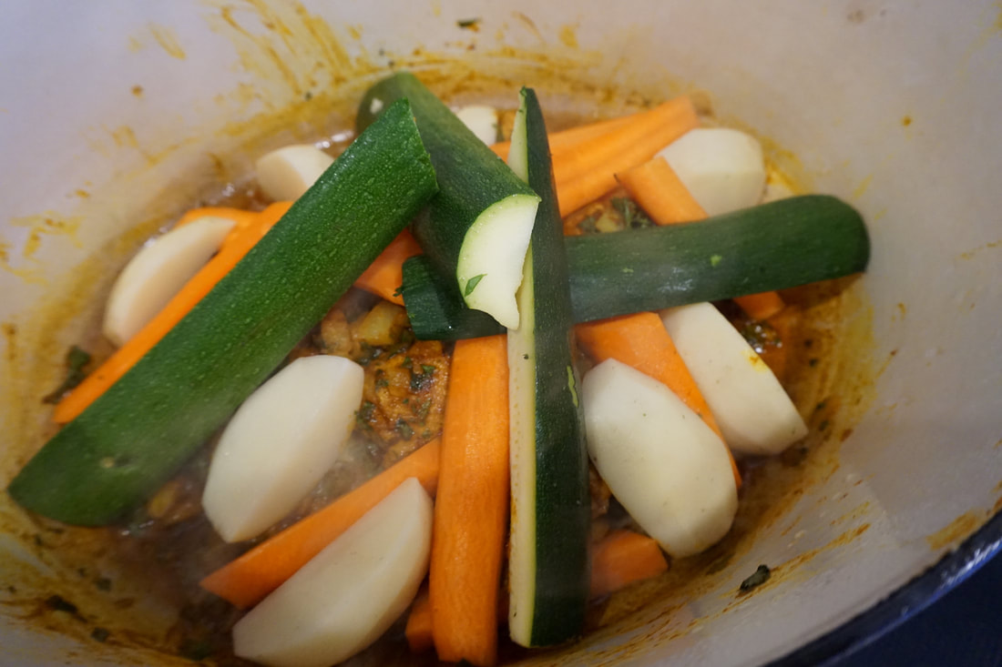 A scene from my virtual Moroccan cooking class: raw potato carrot and zucchini in a pot.